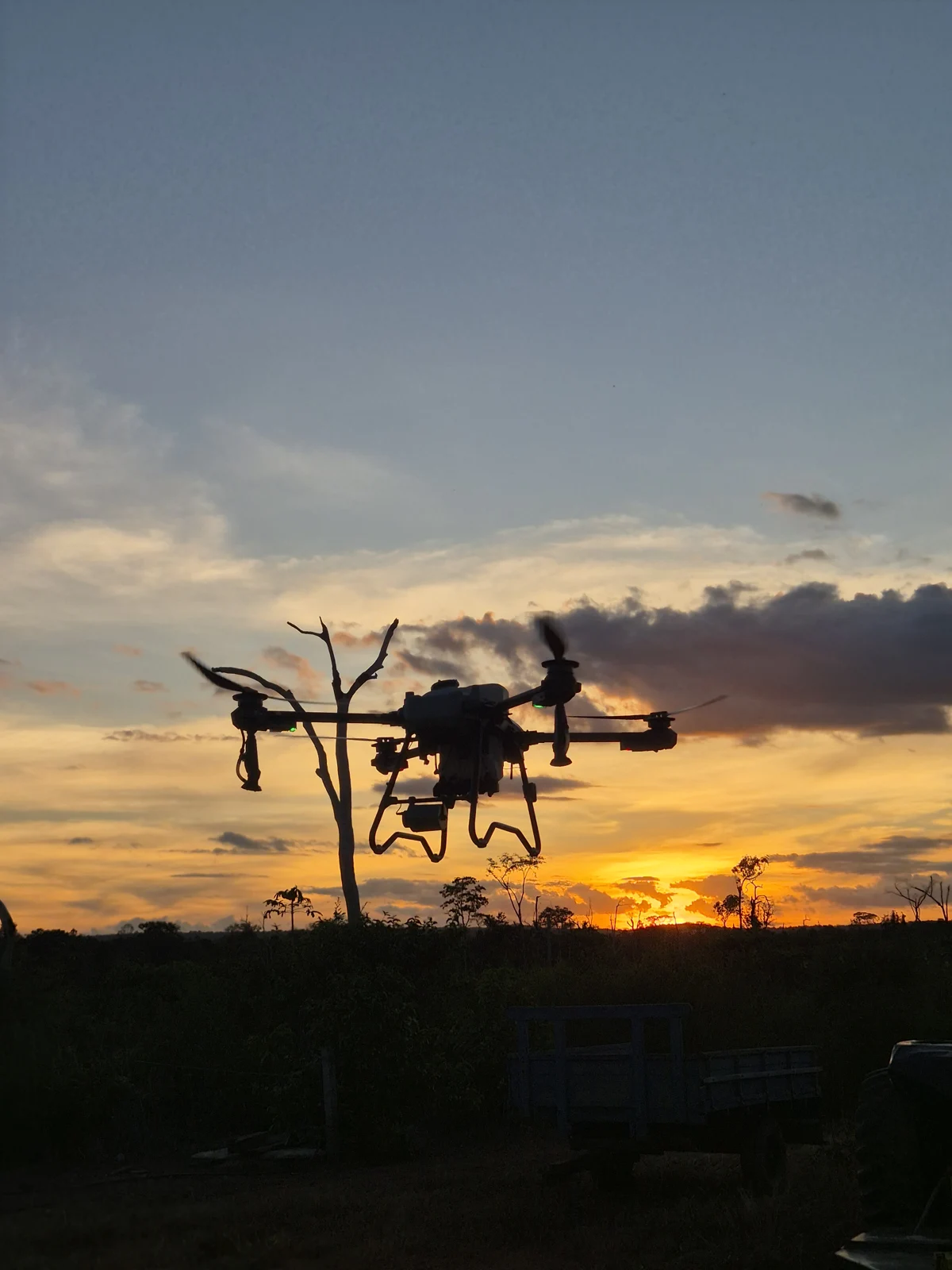 Drone agrícola em voo ao pôr do sol